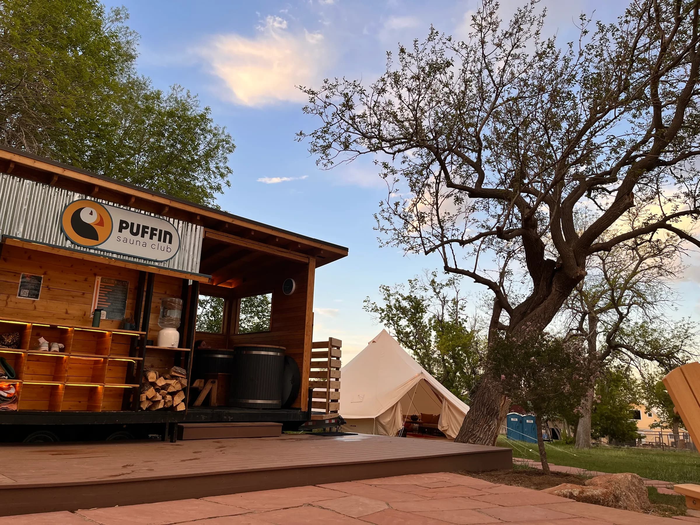The Puffin Sauna Club mobile sauna and event tent at dusk, Yellow Barn Farm